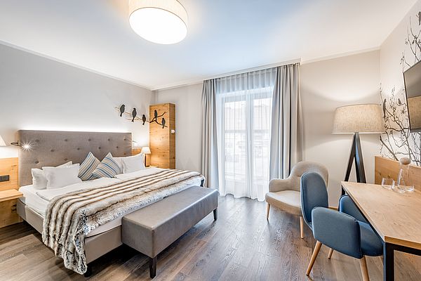 Hotelzimmer mit Doppelbett, Schreibtisch und Blick auf den Ort