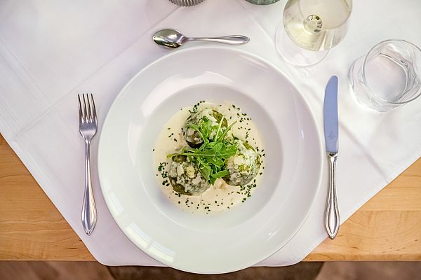 Spinatknödel mit Käsesauce, Parmesan und frischem Rucola