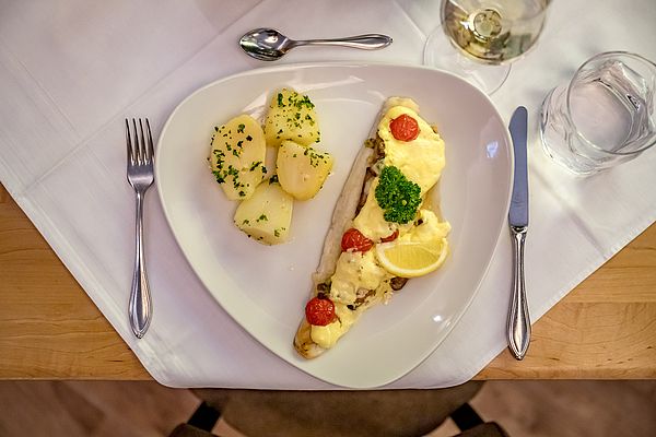 Überbackener Fisch mit Käse, Tomaten und Petersilerdäpfeln